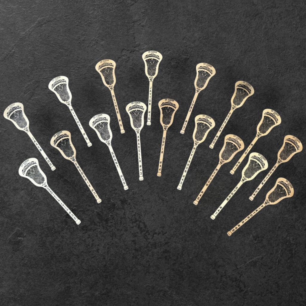 Wood cutouts of mini lacrosse sticks with player names and numbers on the handle.